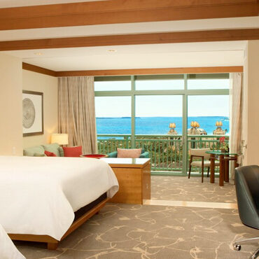 A hotel room with a view of the ocean.